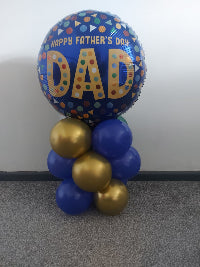 Helium balloon arrangement with a large 'Happy Father's Day DAD' balloon on a plain background